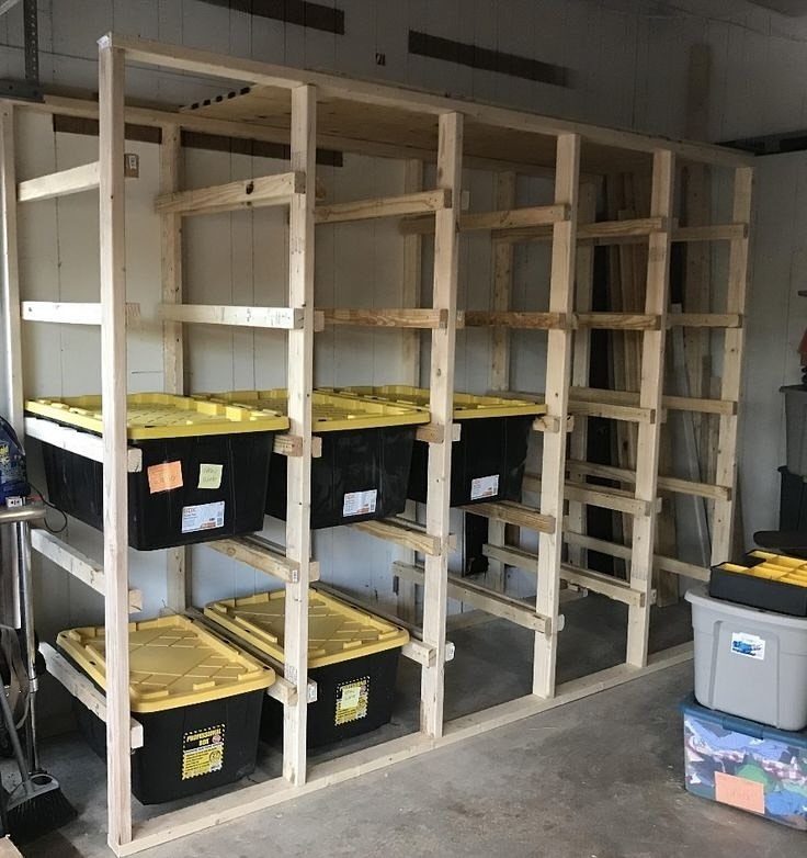 Garage Storage for Lawn Equipment: 7 Ideas That Actually Fit 5 Wooden shelving unit in a garage holding several black and yellow plastic storage bins.