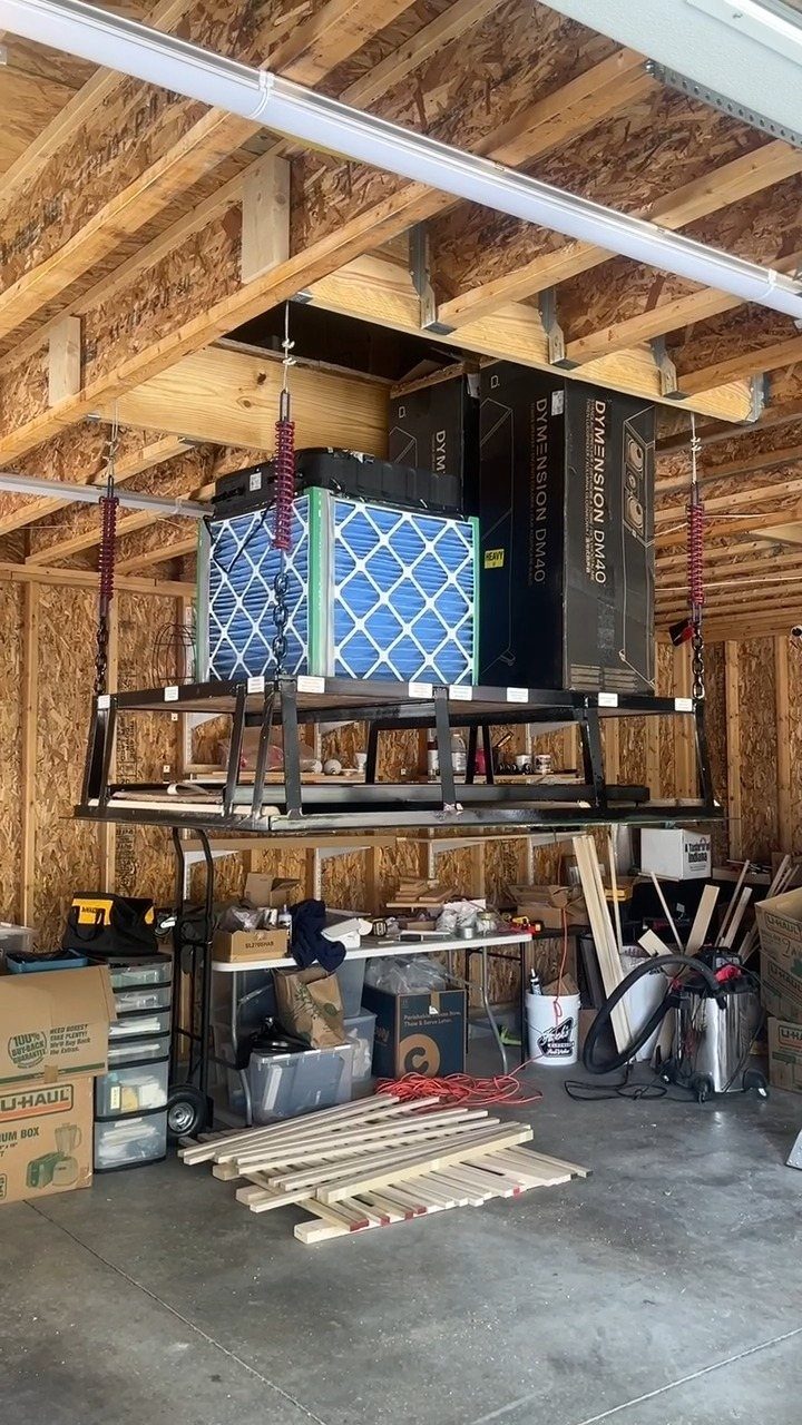 Garage Storage for Lawn Equipment: 7 Ideas That Actually Fit 6 Overhead metal storage rack suspended from garage ceiling joists holding large boxes and equipment.