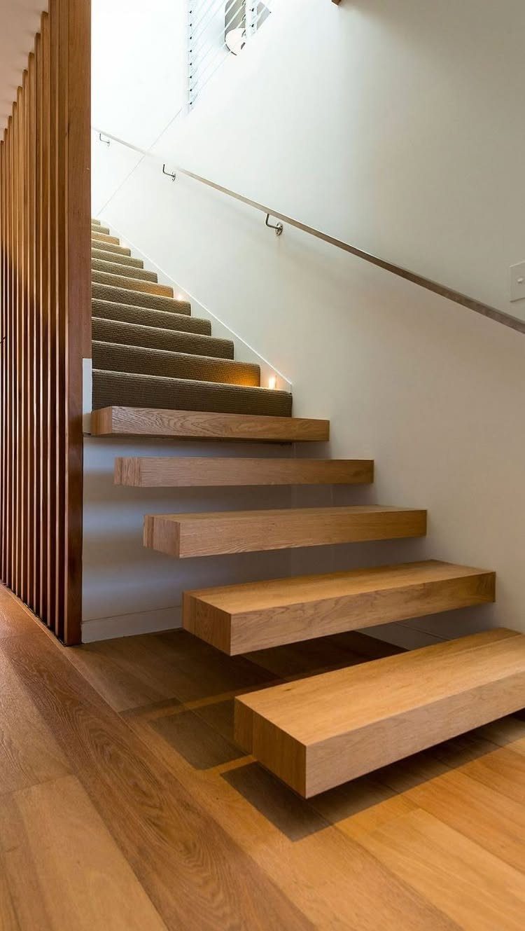 Home Stairs Design: 12 Ideas from Glass Treads to Built-In Storage 6 Thick wooden cantilevered stair treads protruding from a white wall above a light wood floor.