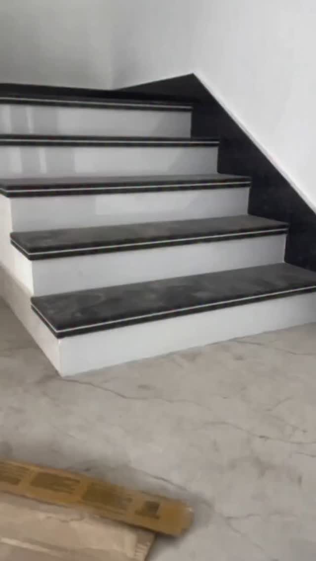 Home Stairs Design: 12 Ideas from Glass Treads to Built-In Storage 13 White stairs with dark grey treads and thin white borders against a white wall.