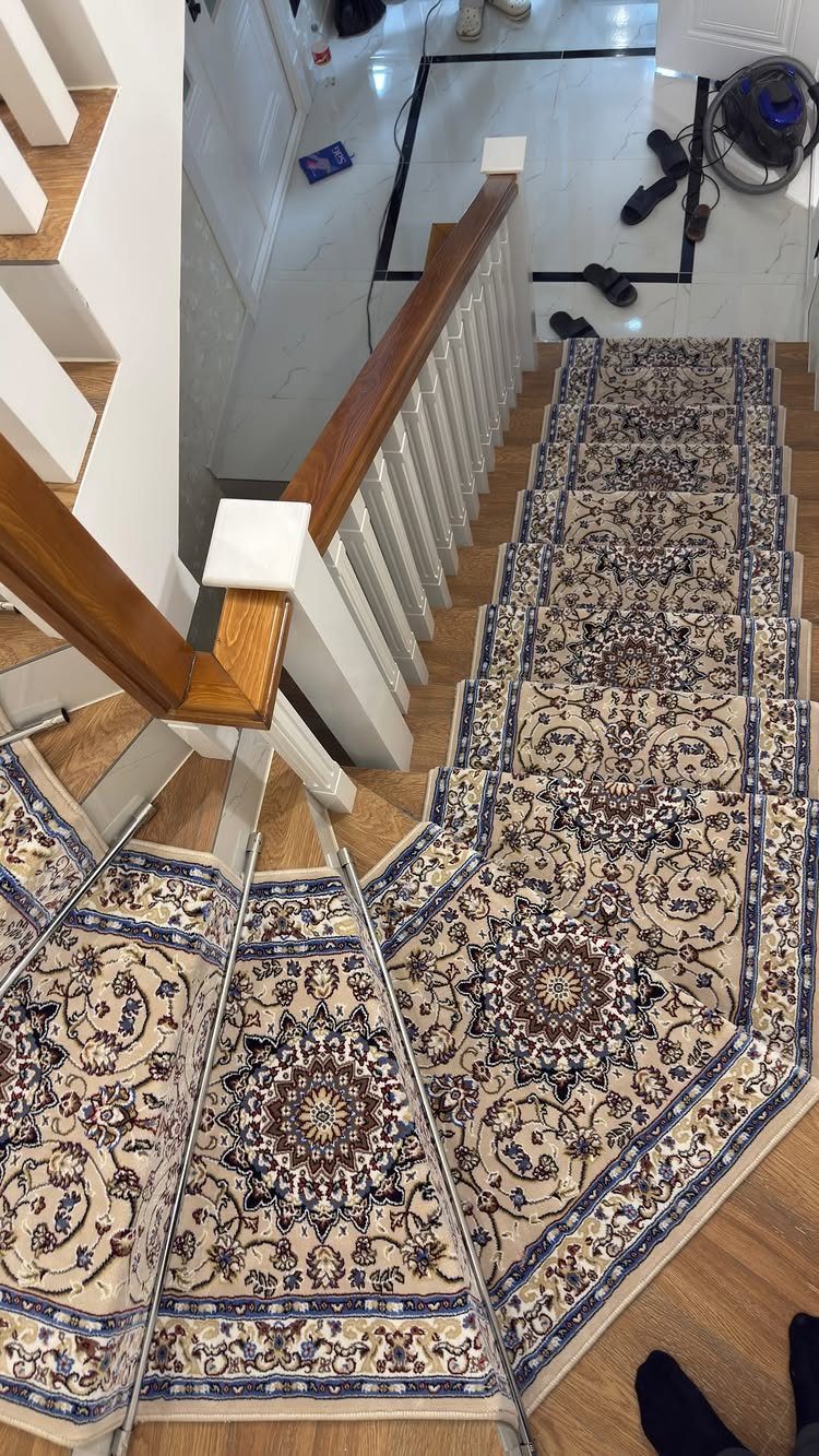 Home Stairs Design: 12 Ideas from Glass Treads to Built-In Storage 10 A patterned beige and blue floral staircase runner installed on wooden stairs with white spindles.