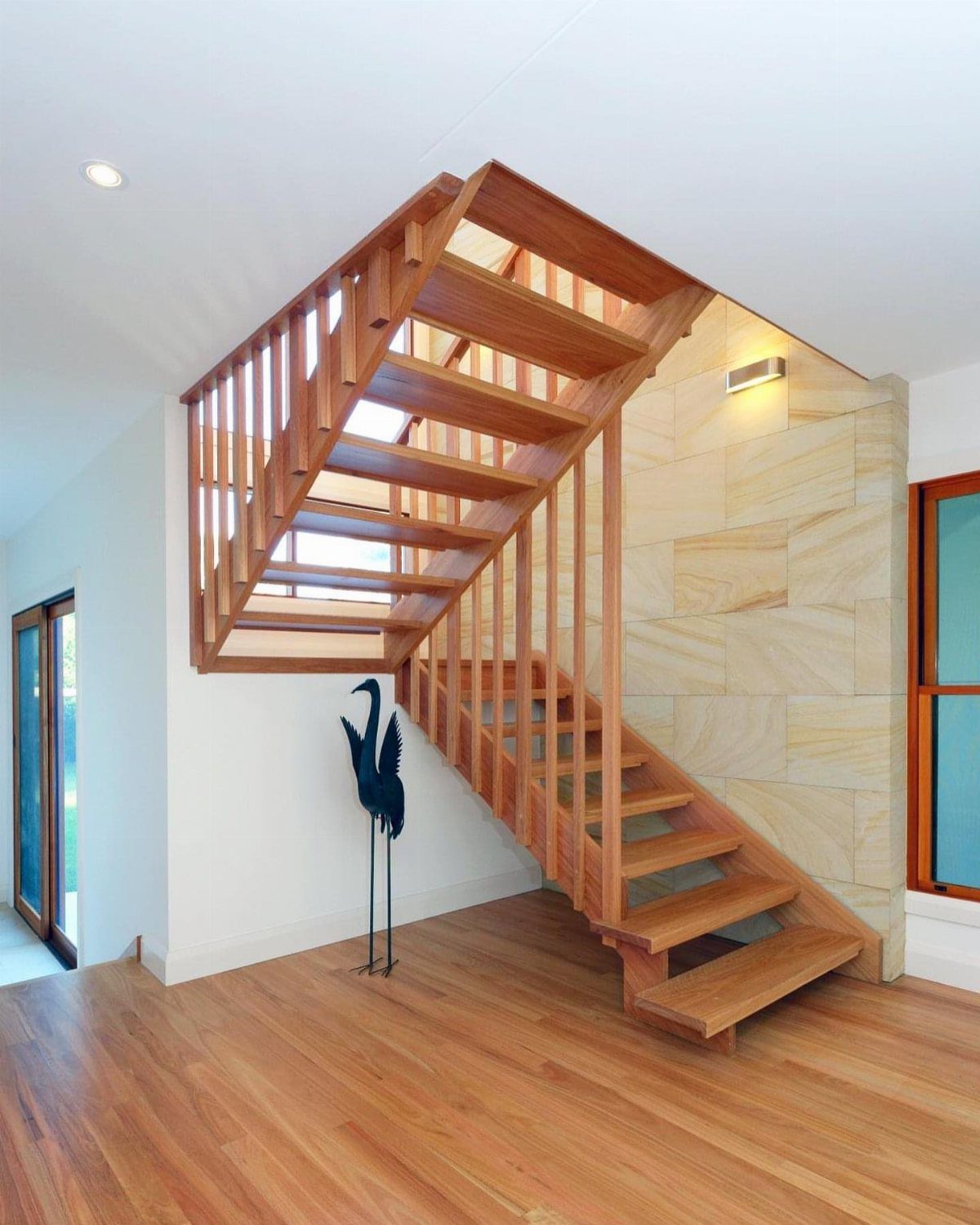 Home Stairs Design: 12 Ideas from Glass Treads to Built-In Storage 5 Wooden staircase with an open design and a landing connecting two flights of stairs.