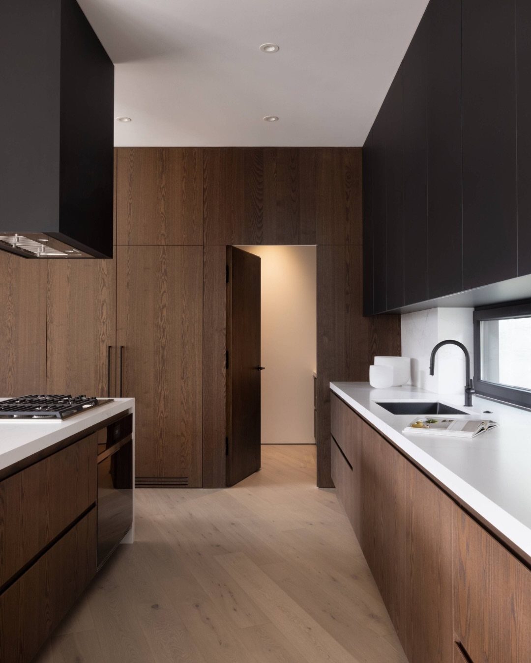 Kitchen with Hidden Pantry: 8 Ideas That Blend Right In 5 Modern kitchen with dark wood paneled walls and a seamless flush pantry door.