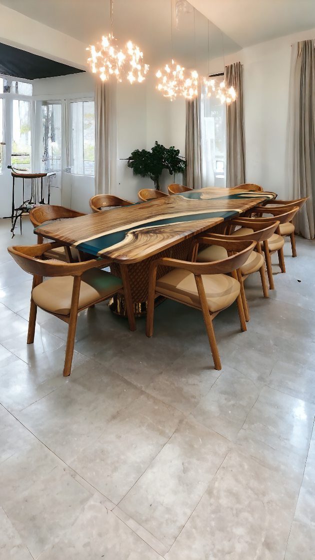 A long wooden river table with blue resin surrounded by ten tan upholstered dining chairs.