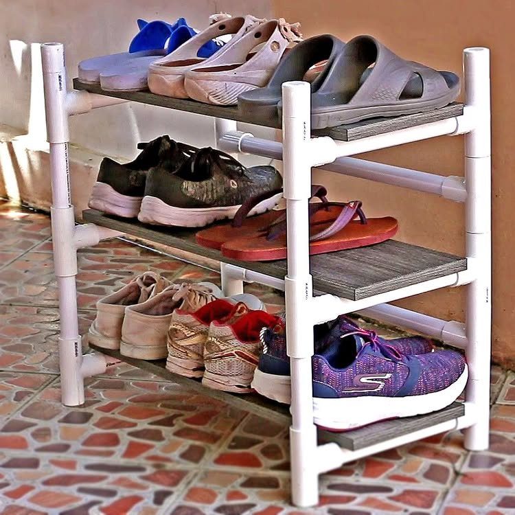 RV Shoe Storage: 6 Ideas That Save Space and Sanity 2 A three-tier shoe rack made from white PVC pipes and wooden planks holding various footwear.