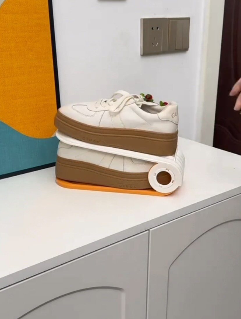RV Shoe Storage: 6 Ideas That Save Space and Sanity 4 Two white sneakers stacked vertically using a white plastic space-saving organizer on a white cabinet.