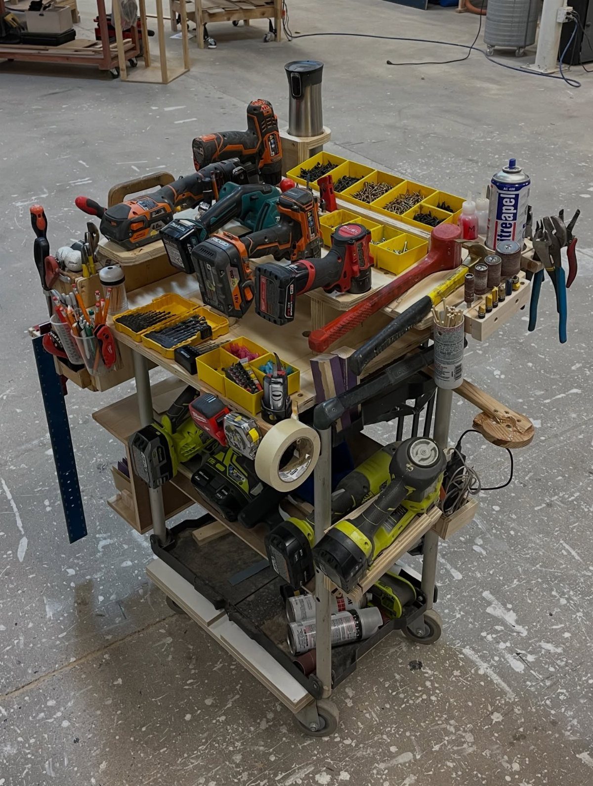 13 Shop Tool Storage Ideas for Pegboard, Carts and Cabinets 6 A wooden mobile tool cart filled with various power tools and organizers in a workshop.