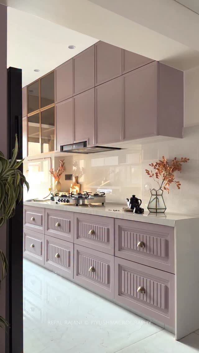 18 Small Kitchen Remodel Ideas to Open Up Your Space 8 Light mauve kitchen cabinets with white countertops and a white tiled backsplash in a bright room.