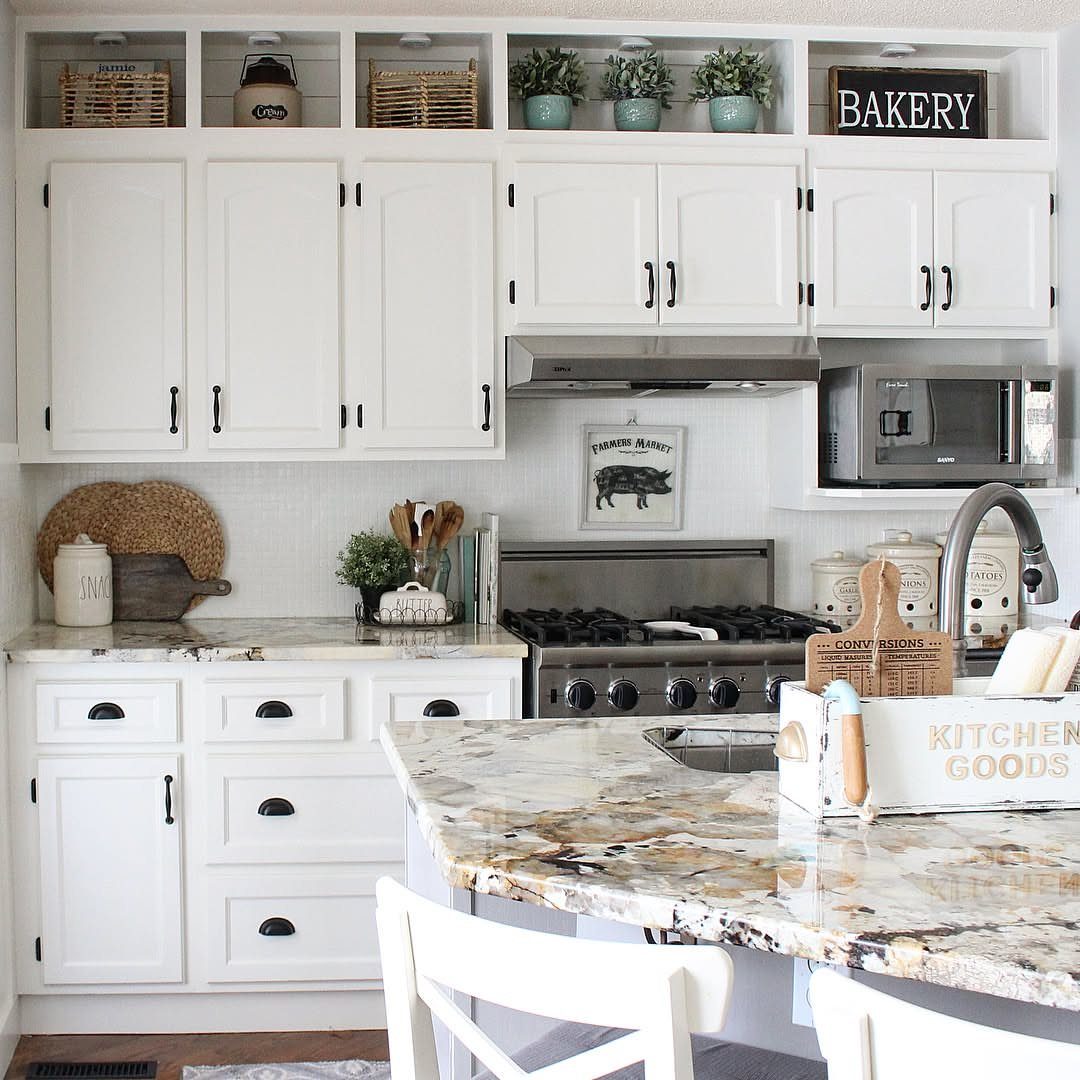 12 Storage Ideas for Small Homes to Add Extra Space Fast 10 White kitchen cabinets with decorative baskets and plants stored on open shelves above the upper cabinets.