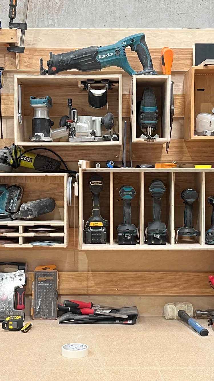 Tool Wall Storage: 8 Ideas for Garage and Workshop 7 Custom wooden wall storage compartments holding various power tools and cordless drills in a workshop.