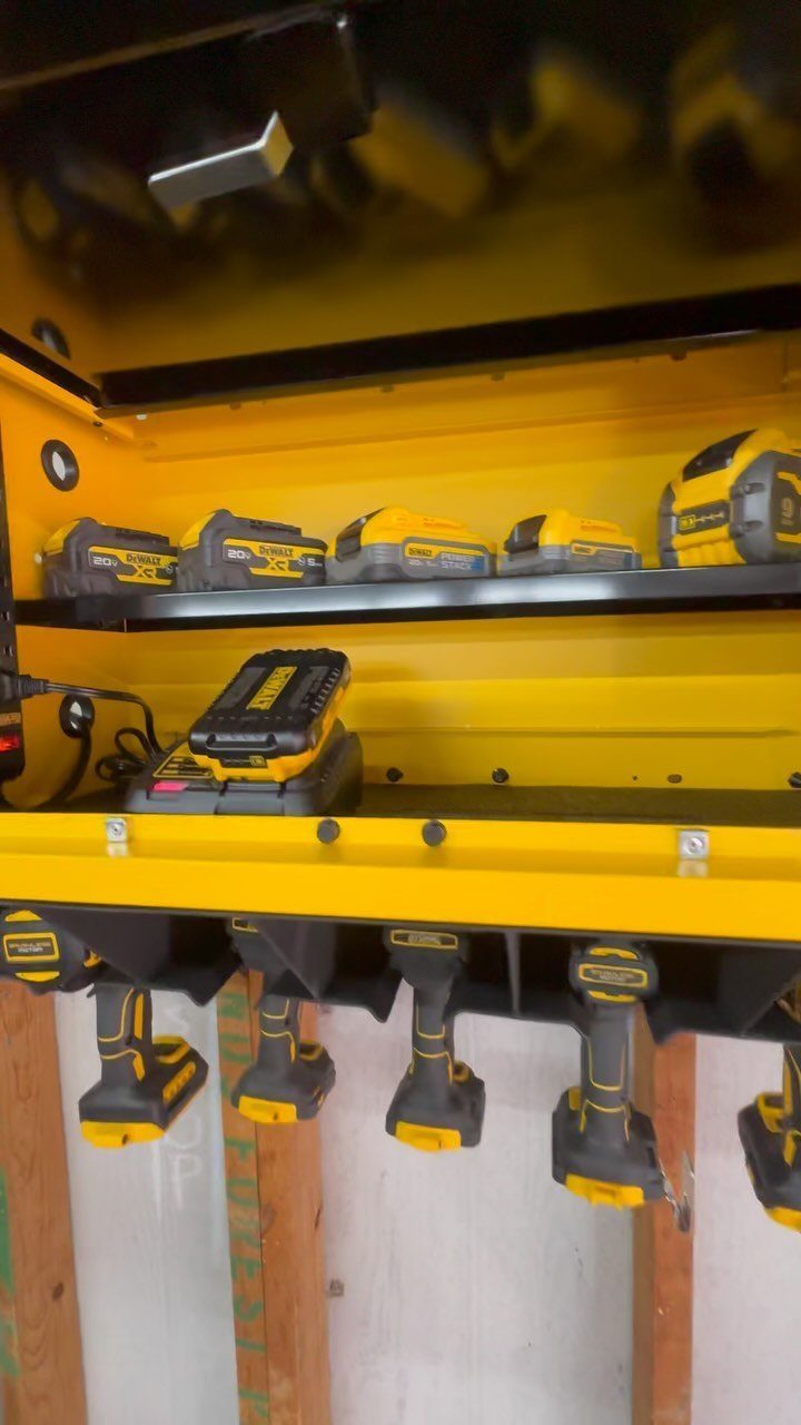 Tool Wall Storage: 8 Ideas for Garage and Workshop 5 Yellow DEWALT power tool storage shelf holding batteries and hanging cordless drills on a wall.