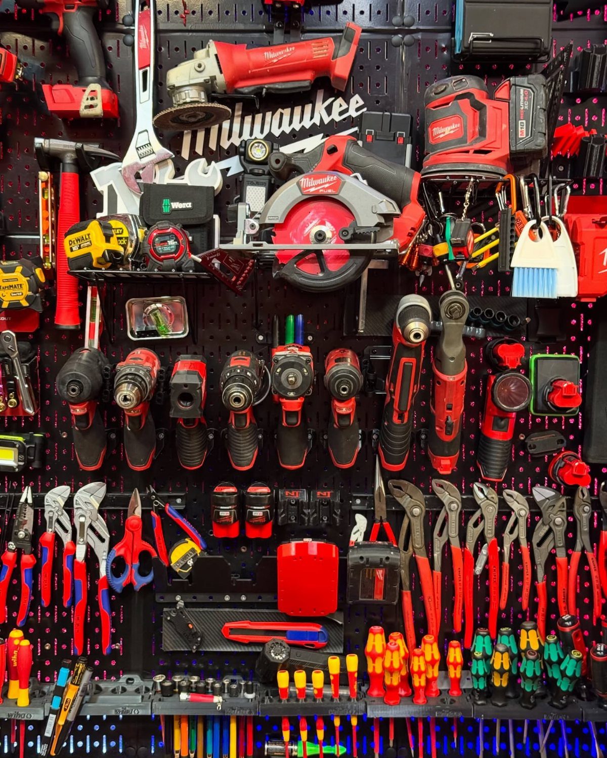 Tool Wall Storage: 8 Ideas for Garage and Workshop 2 Various red and black power tools and hand tools organized on a black pegboard wall system.