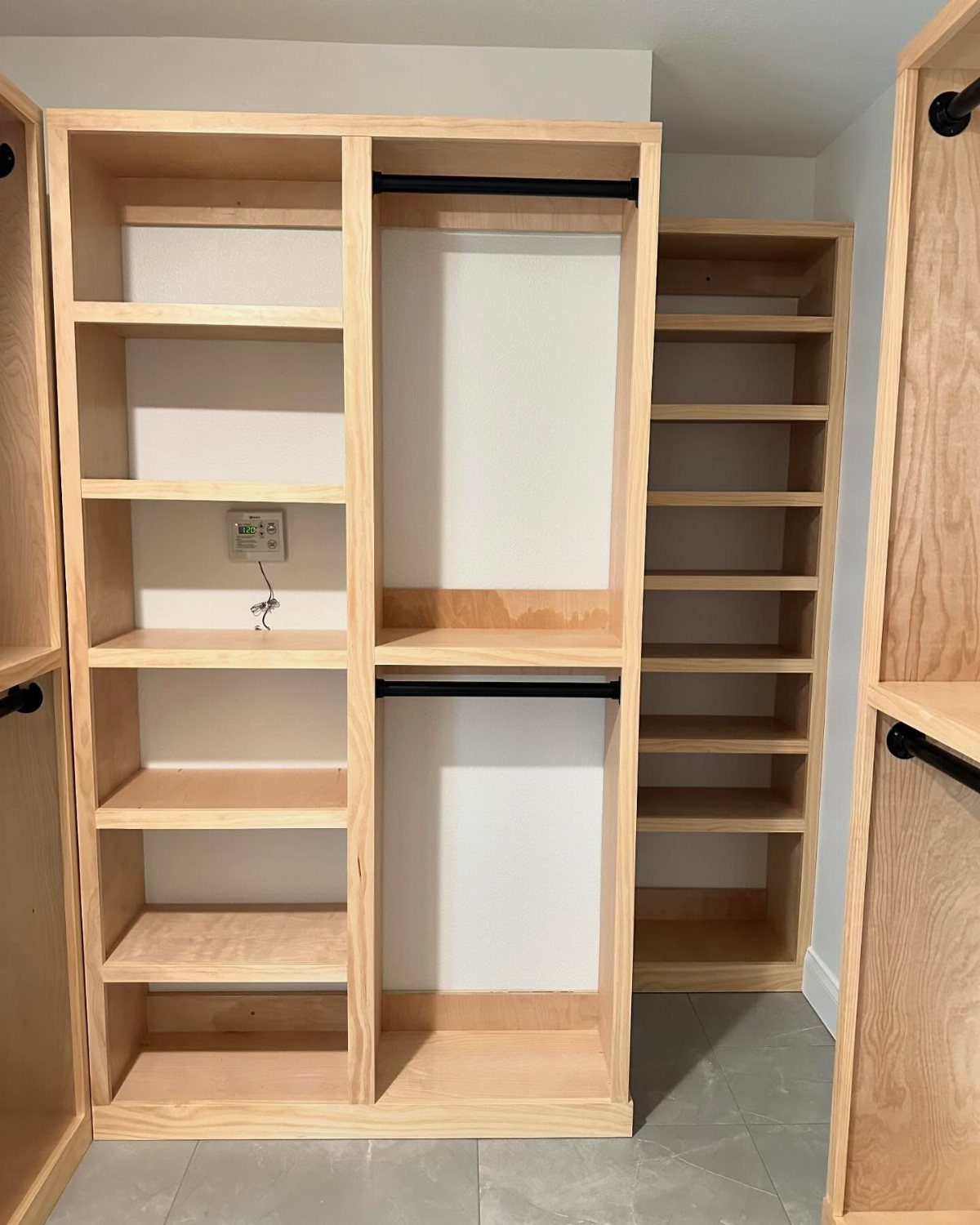 Walk in Closet Storage: 9 Ideas That Work in Real Homes 10 Light wood closet shelving units with open compartments and black hanging rods against a white wall.