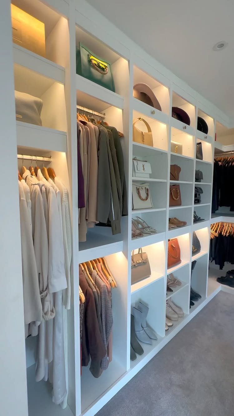 Walk in Closet Storage: 9 Ideas That Work in Real Homes 2 White built-in closet shelving units with integrated lighting holding handbags, hats, and hanging clothes.