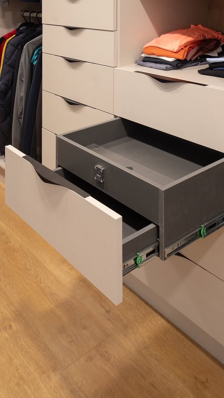 Walk in Closet Storage: 9 Ideas That Work in Real Homes 4 An open white drawer with a dark grey interior inside a modern white closet system.