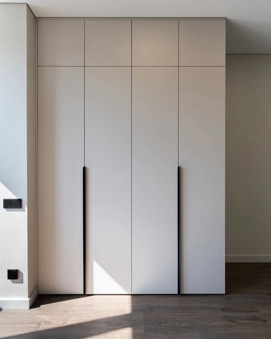 14 Wardrobe Interior Design Ideas for Every Bedroom 15 Minimalist white built-in wardrobe with long black vertical handles and clean lines.